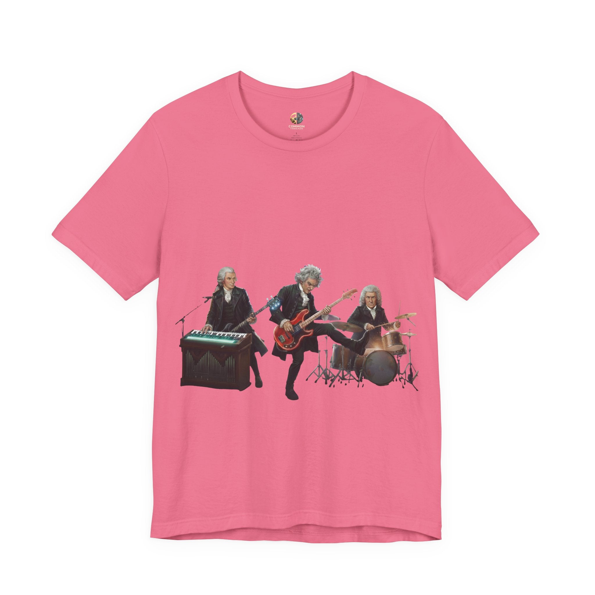Charity pink t-shirt featuring Mozart on bass and keyboard, Beethoven on electric guitar, and Bach on drums in a rock band scene