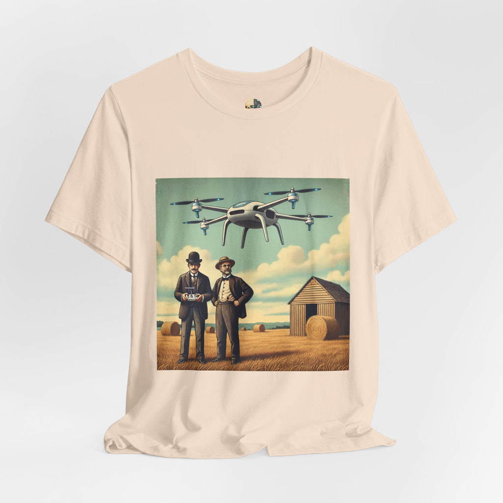 Soft creme T-shirt featuring a graphic of the Wright brothers standing in a hayfield operating a modern quadcopter drone