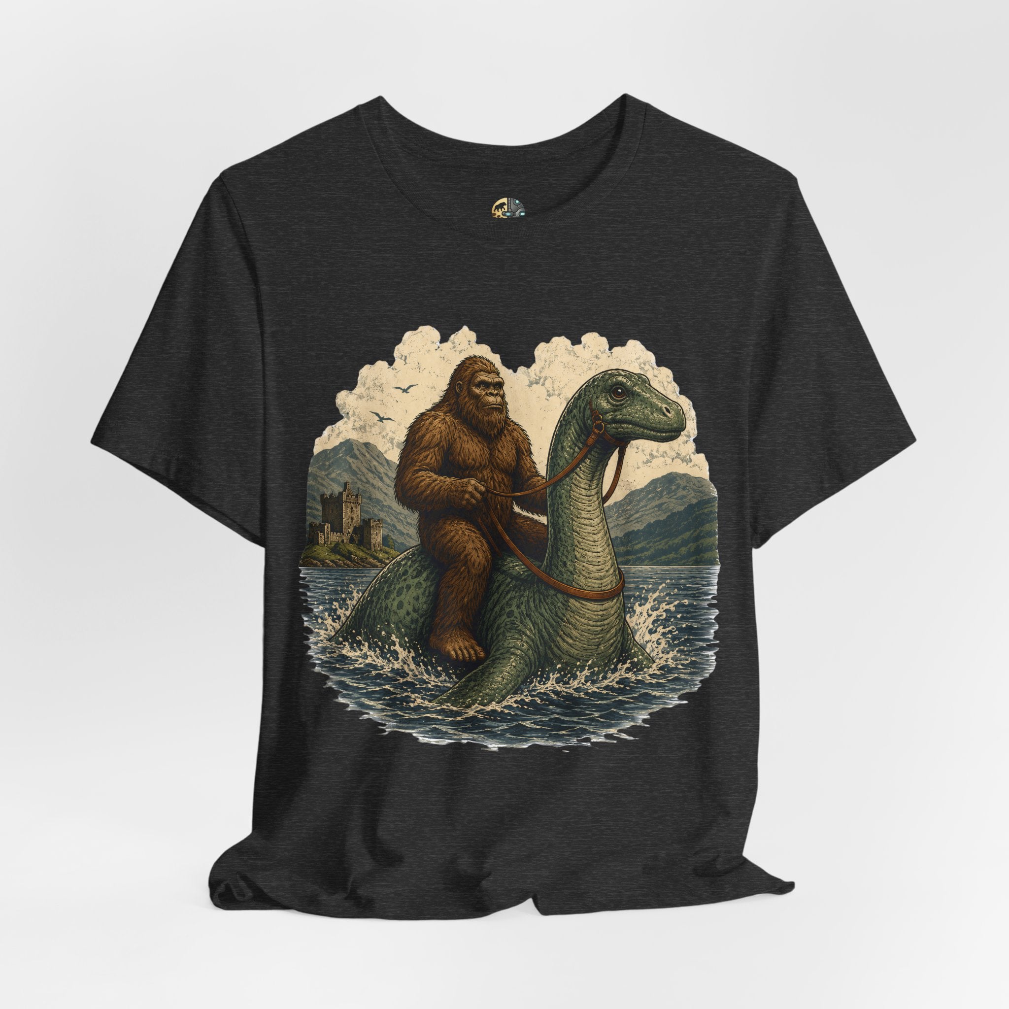 Dark grey heather t-shirt featuring bigfoot riding on the Loch Ness monster