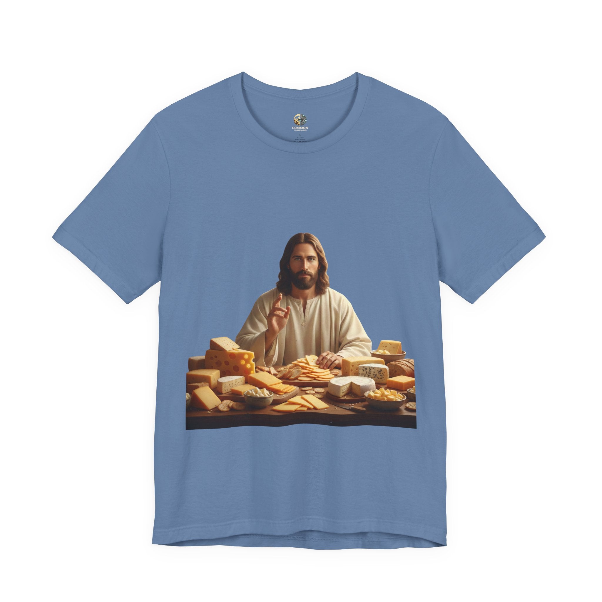 Lavender blue T-shirt featuring a graphic of Jesus in traditional robes seated before a table filled with various cheeses, referencing a ‘Cheeses Sliced’ wordplay