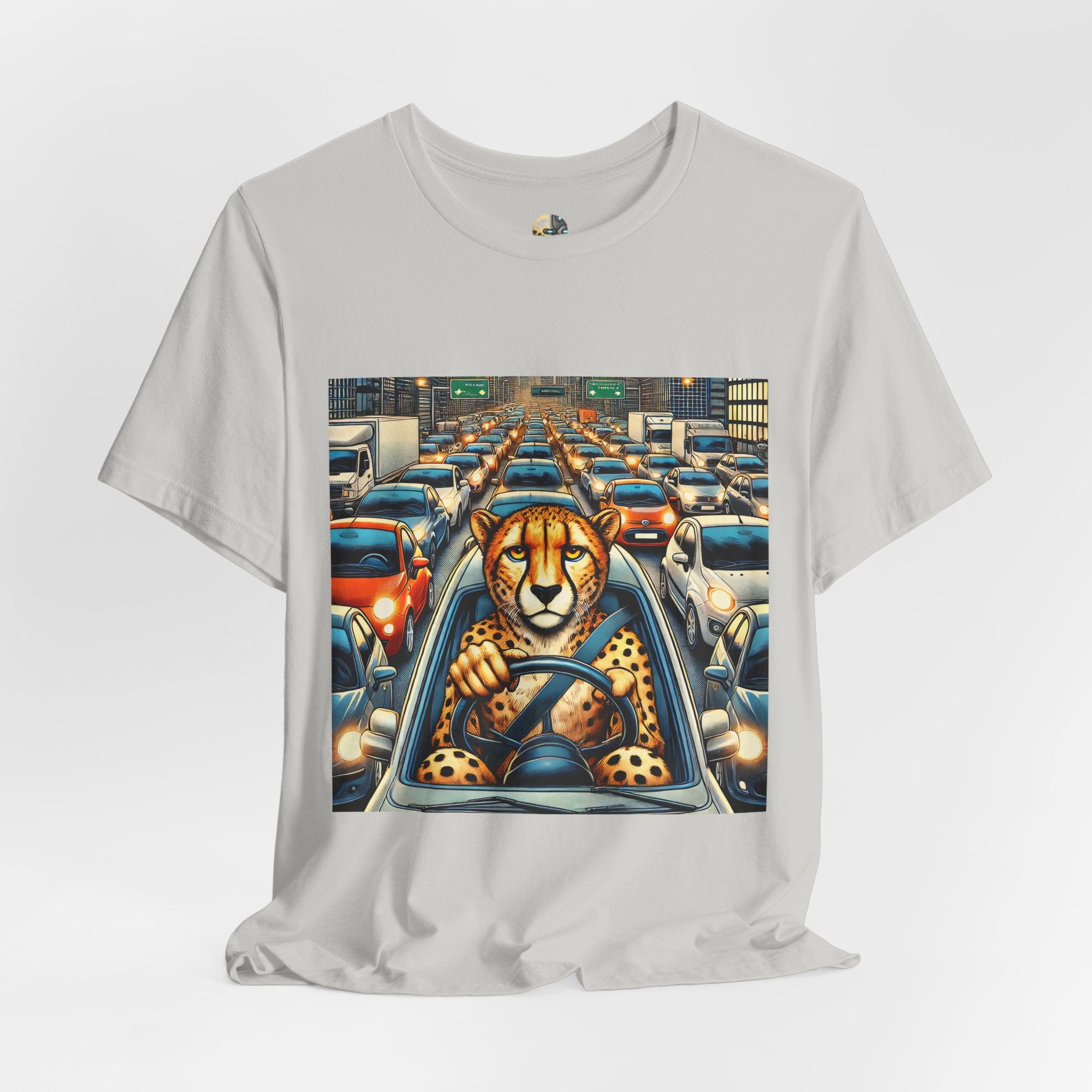 Silver T-shirt featuring a graphic of a cheetah sitting in the driver’s seat of a car stuck in heavy city traffic