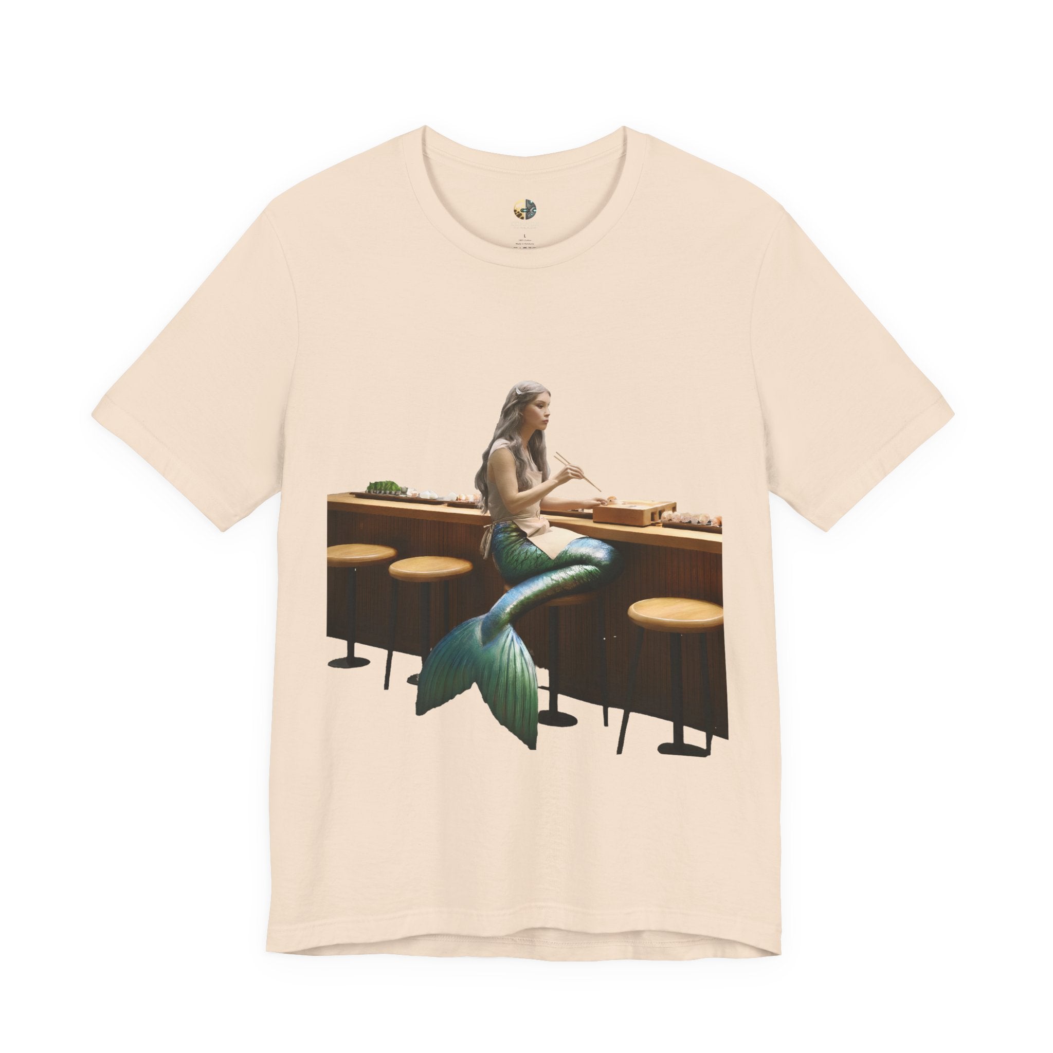 Soft creme T-shirt with graphic of a mermaid wearing a chef’s apron sitting at a sushi bar and eating sushi with chopsticks