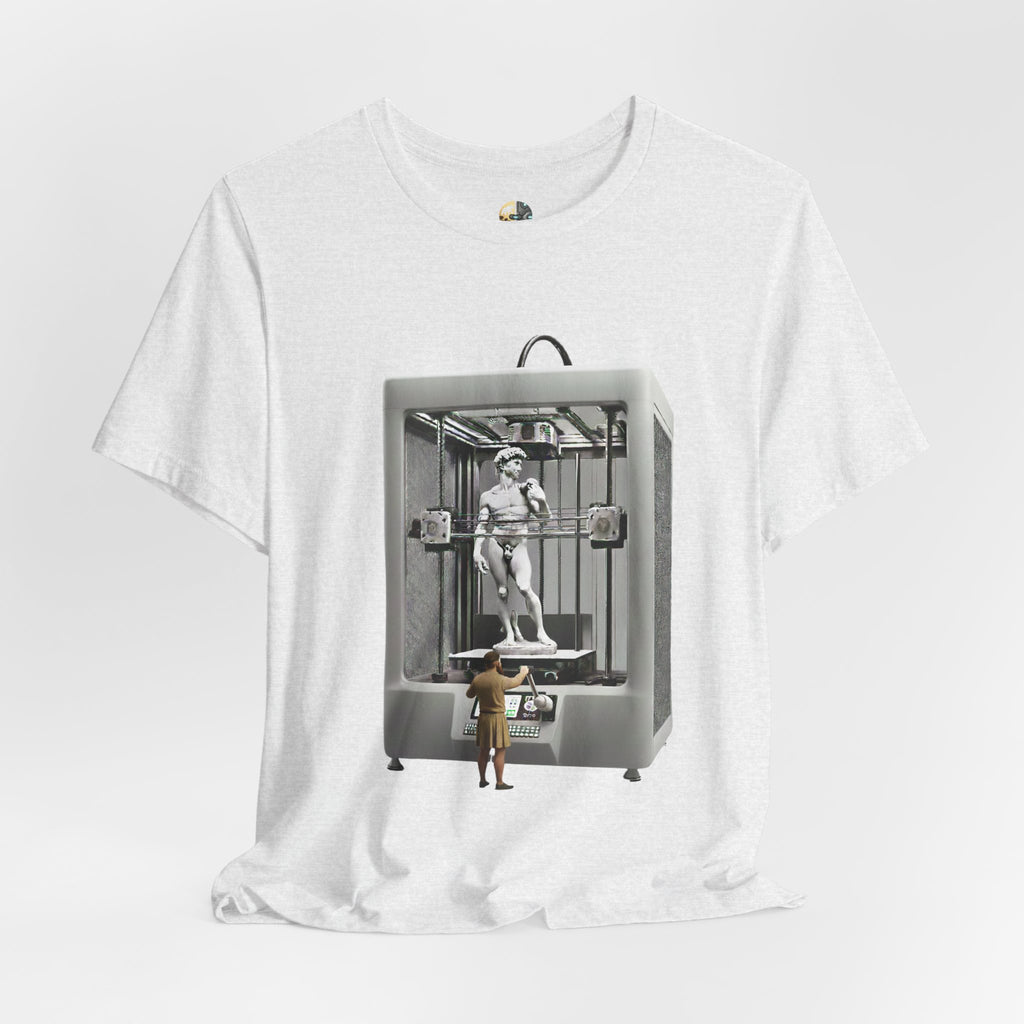 Ash color T-shirt featuring a graphic of Michelangelo’s David statue being created inside a large 3D printer, with Michelangelo standing at the controls