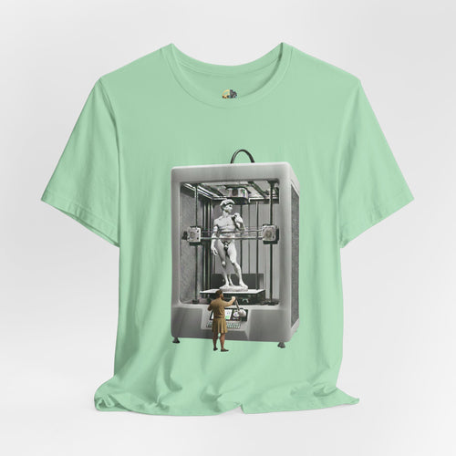 Mint green T-shirt featuring a graphic of Michelangelo’s David statue being created inside a large 3D printer, with Michelangelo standing at the controls