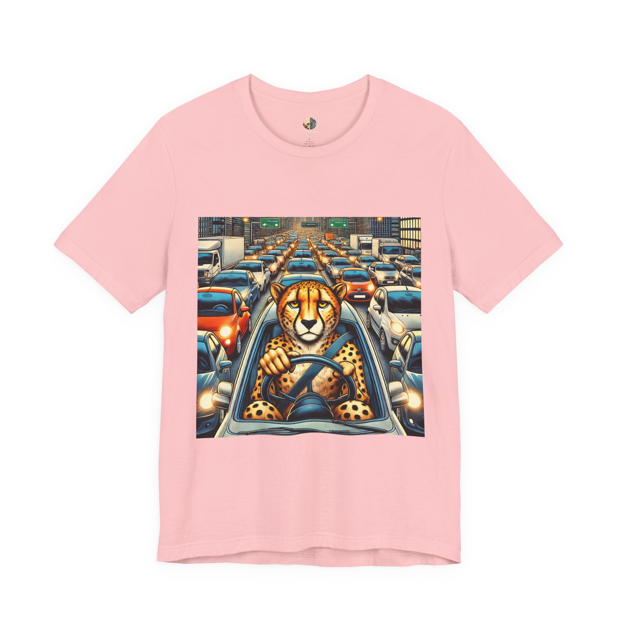 Pink T-shirt featuring a graphic of a cheetah sitting in the driver’s seat of a car stuck in heavy city traffic