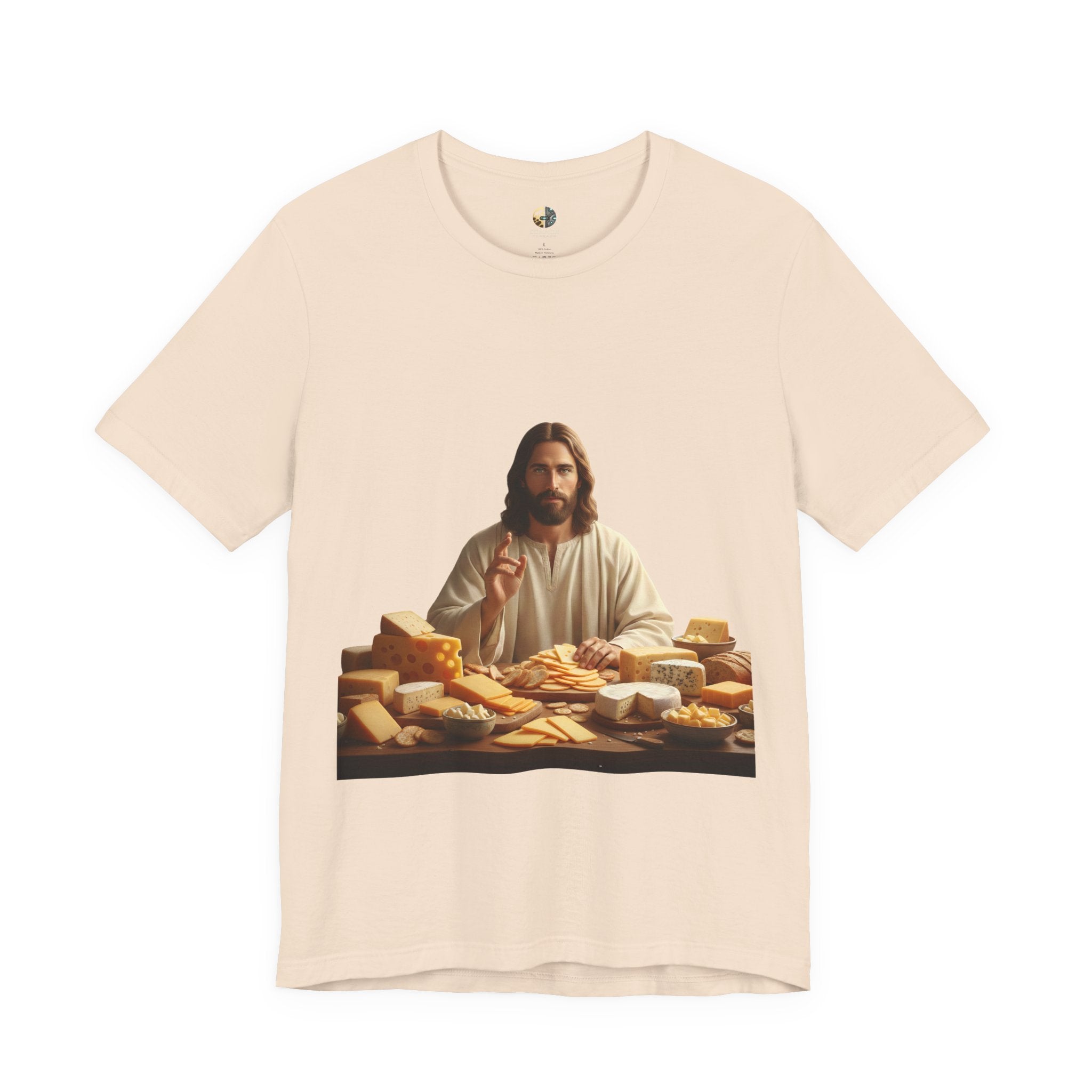 Soft creme T-shirt featuring a graphic of Jesus in traditional robes seated before a table filled with various cheeses, referencing a ‘Cheeses Sliced’ wordplay