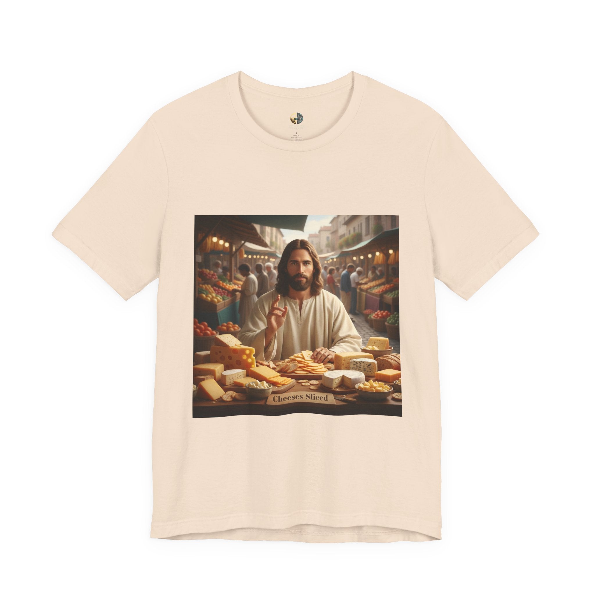Soft creme T-shirt featuring a graphic of Jesus in traditional robes at an ancient marketplace selling assorted cheeses, with a sign reading ‘Cheeses Sliced‘