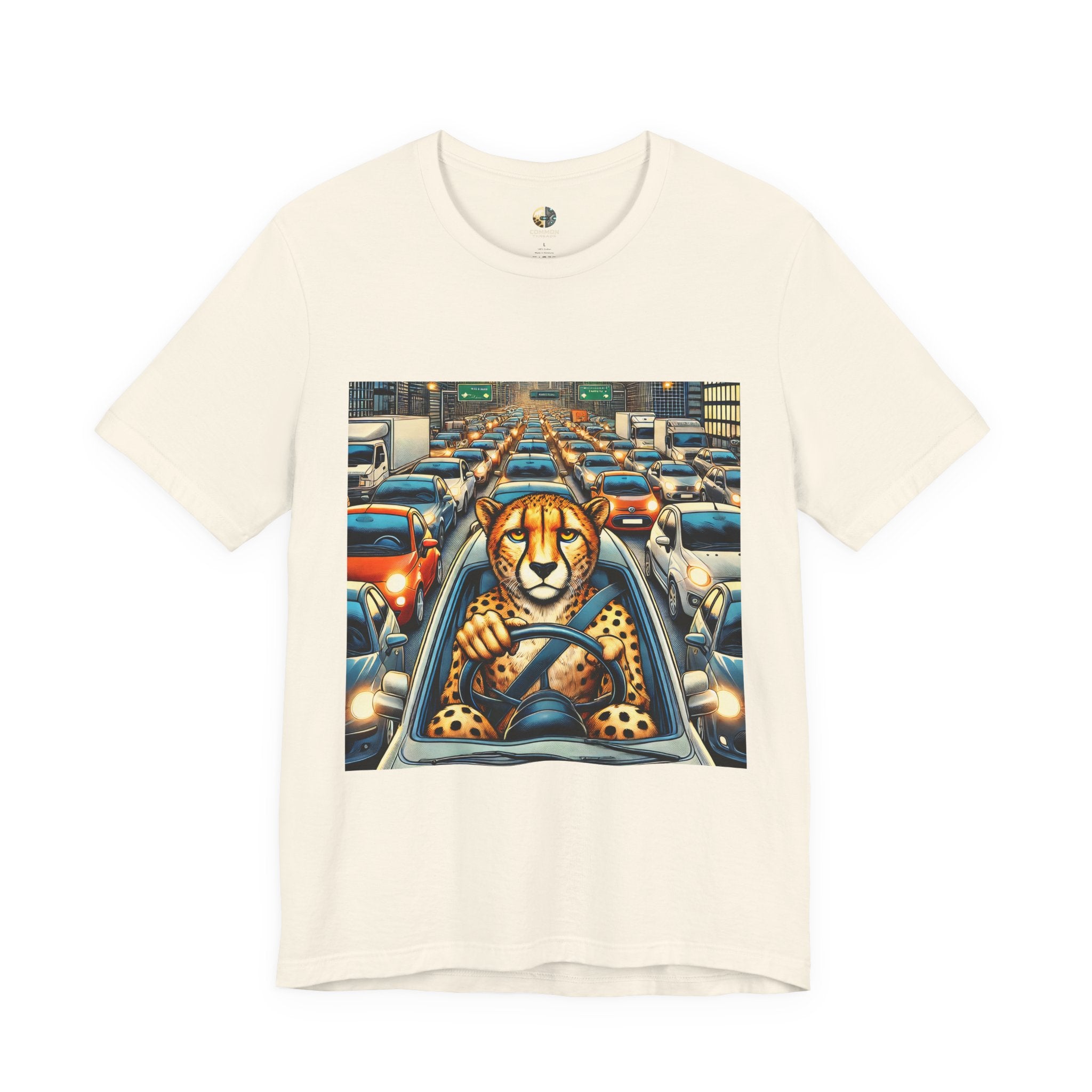 Natural color T-shirt featuring a graphic of a cheetah sitting in the driver’s seat of a car stuck in heavy city traffic