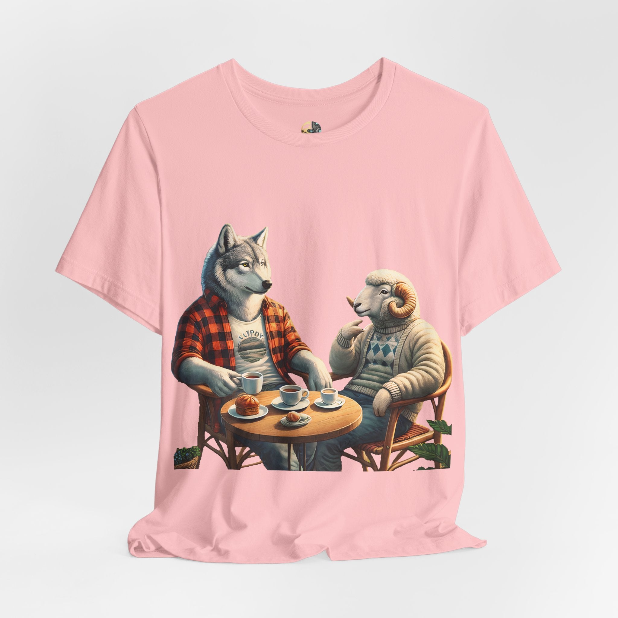 Soft pink T-shirt featuring an anthropomorphic wolf in a flannel shirt and a ram in a patterned sweater sitting at a café table with coffee