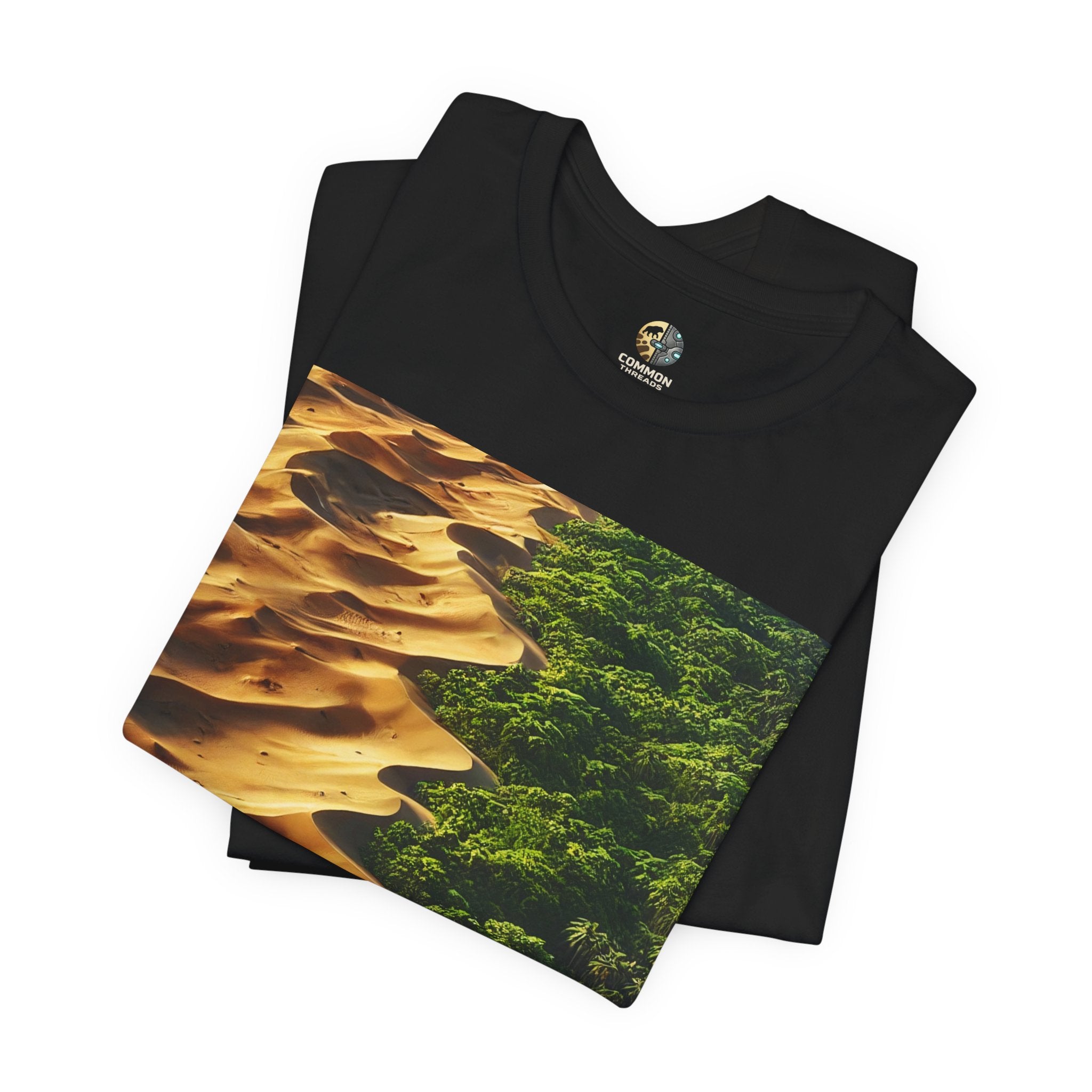 Folded black T-shirt featuring a split landscape with golden desert sand dunes on one side and a dense green rainforest on the other
