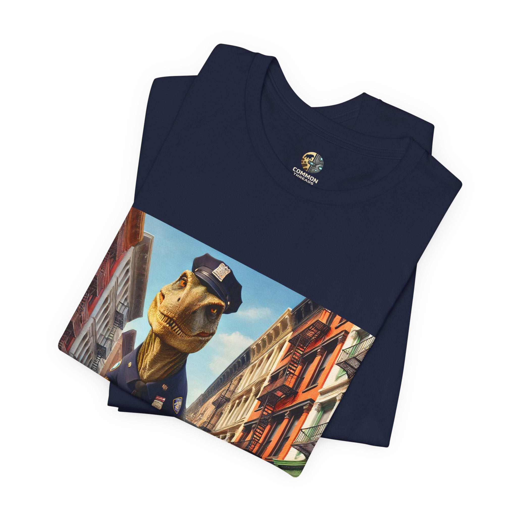 Folded navy blue T-shirt showing a T-Rex and a bunny dressed as police officers standing together on a crosswalk in a New York–style urban setting