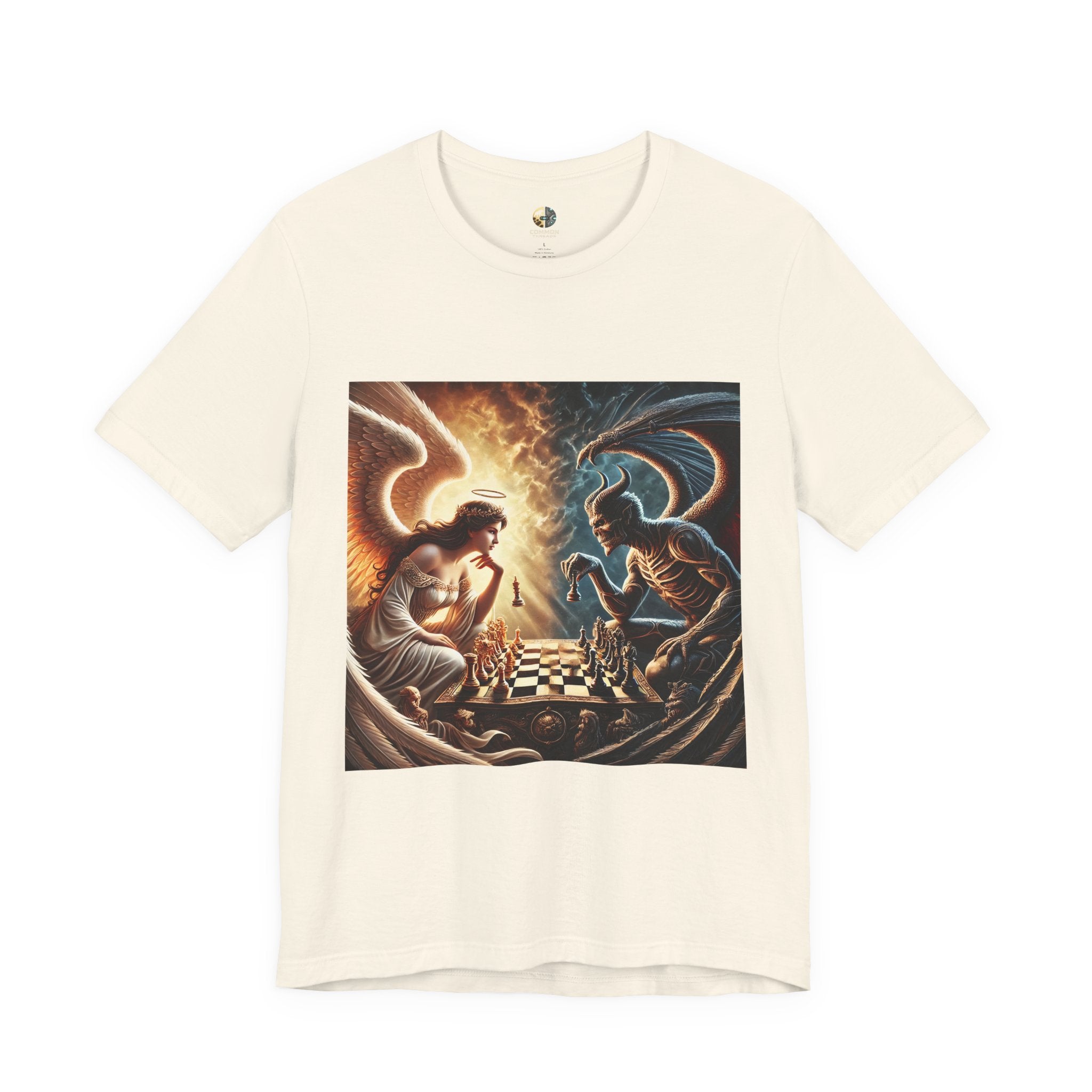 Natural color T-shirt featuring a graphic of an angel and a demon playing chess, with a golden king piece levitating, a dark background behind the demon and warm light tones behind the angel