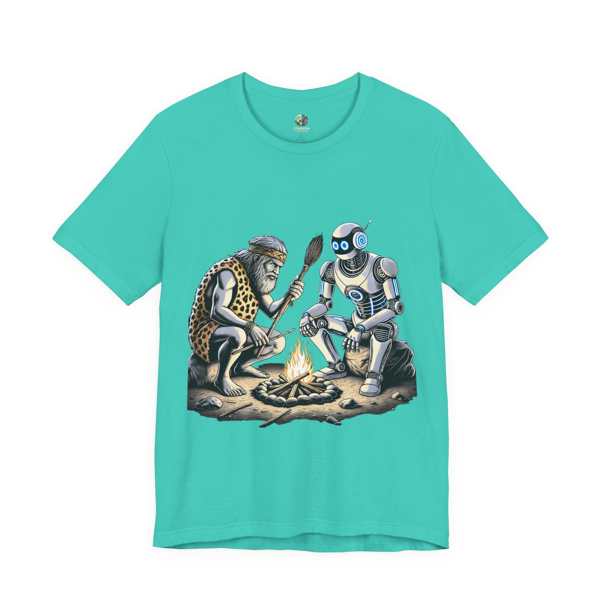 Teal T-shirt featuring a graphic of a bearded caveman in a leopard-print pelt sitting by a campfire with a futuristic robot