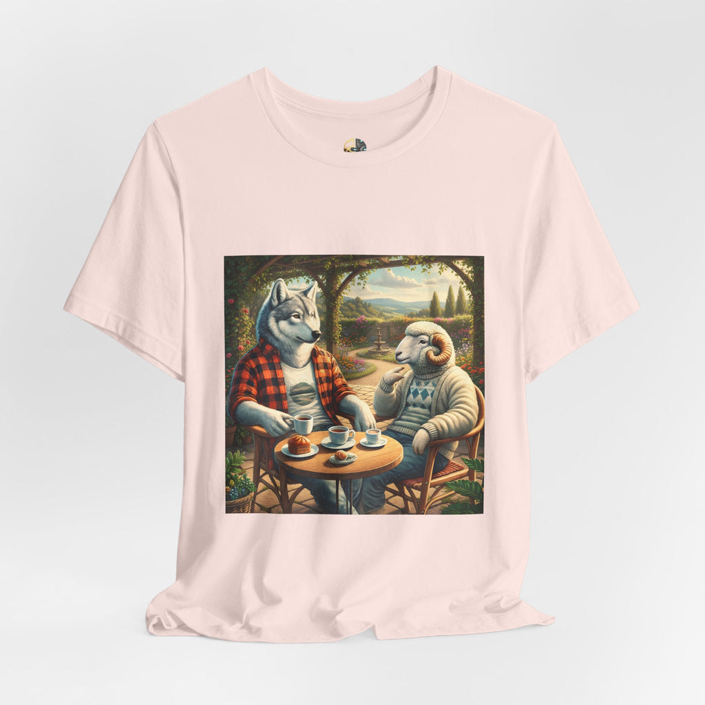 Soft pink color T-shirt featuring a graphic of a wolf in a flannel shirt and a ram in a patterned sweater sitting at a café table drinking coffee on a porch