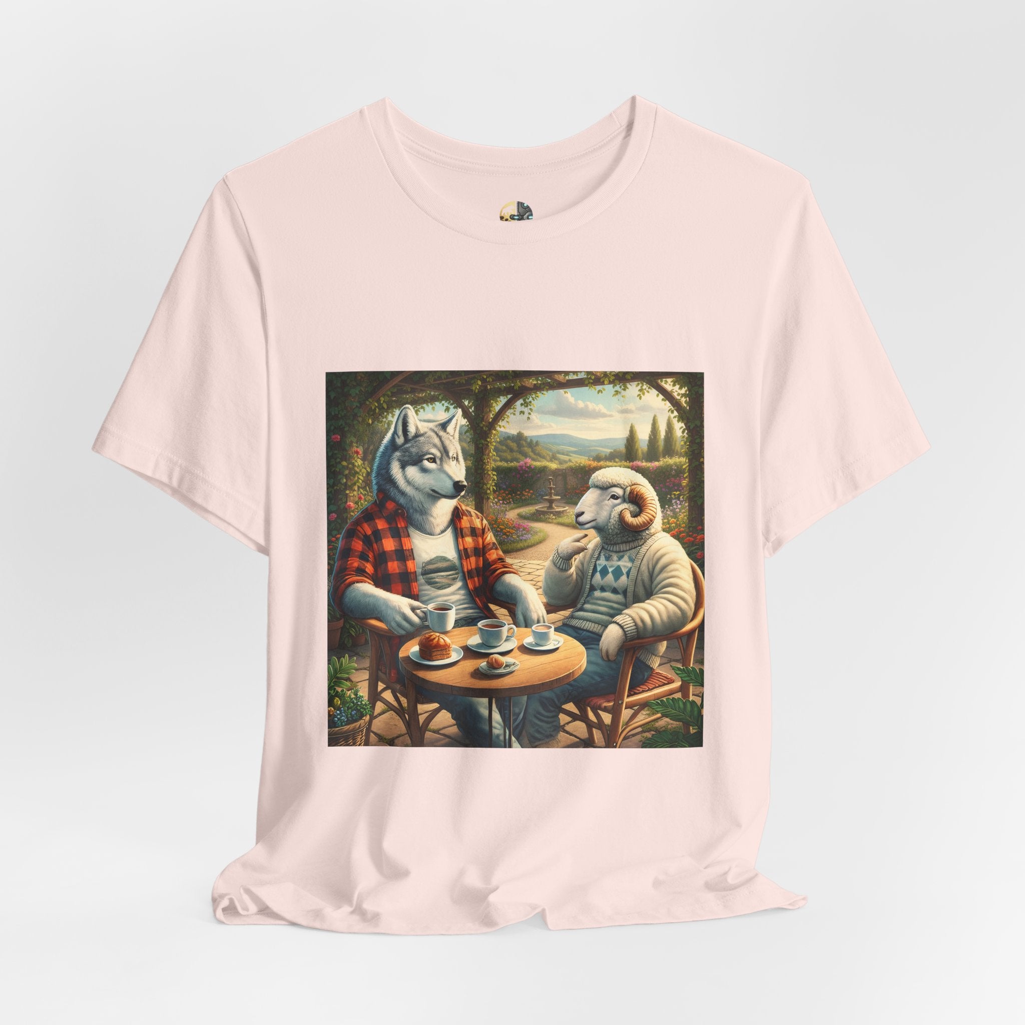 Soft pink color T-shirt featuring a graphic of a wolf in a flannel shirt and a ram in a patterned sweater sitting at a café table drinking coffee on a porch