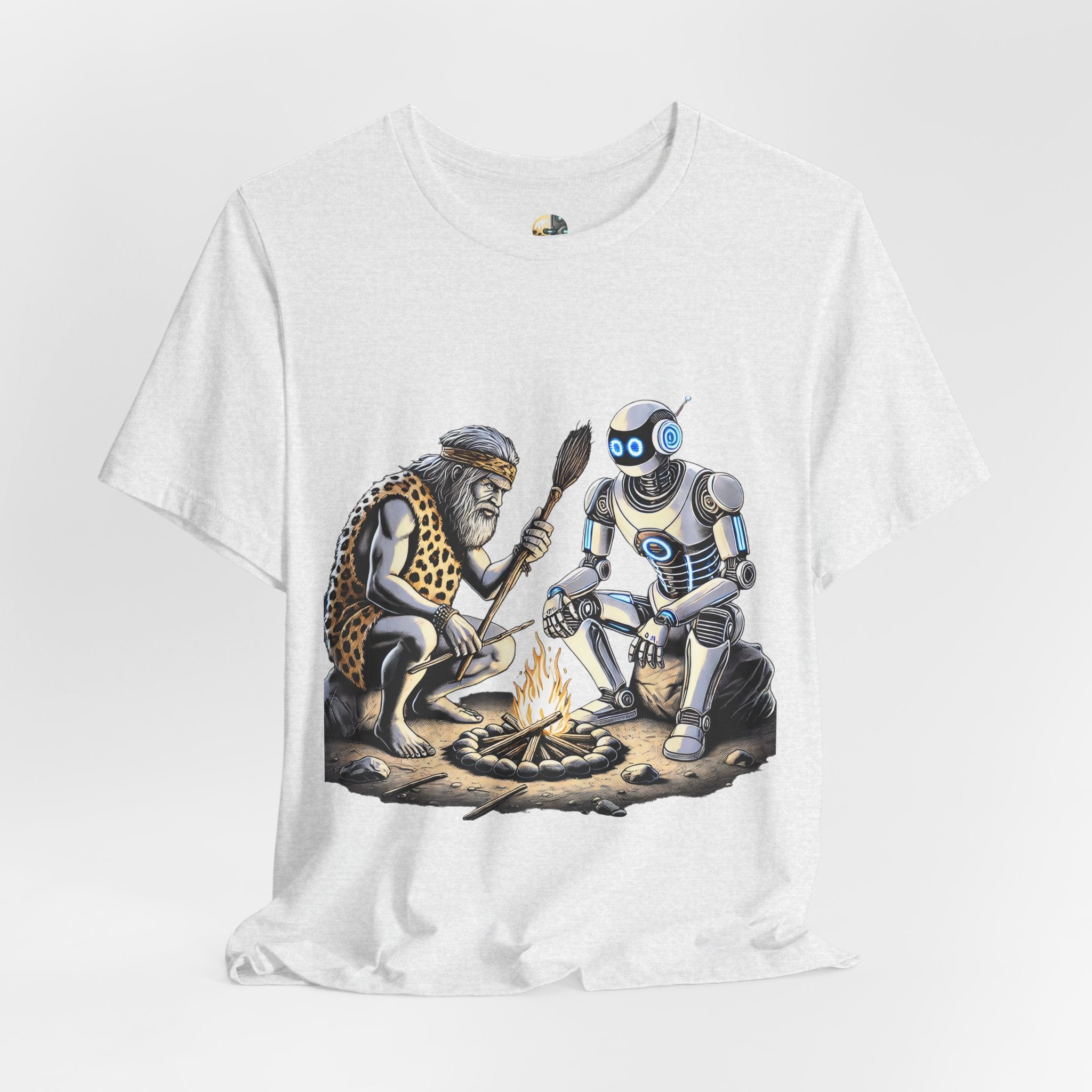 Ash color T-shirt featuring a graphic of a bearded caveman in a leopard-print pelt sitting by a campfire with a futuristic robot