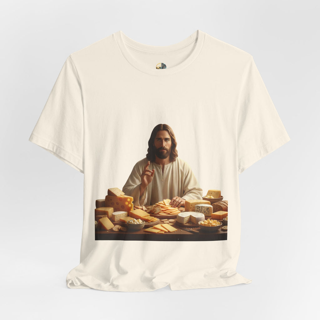 Natural color T-shirt featuring a graphic of Jesus in traditional robes seated before a table filled with various cheeses, referencing a ‘Cheeses Sliced’ wordplay