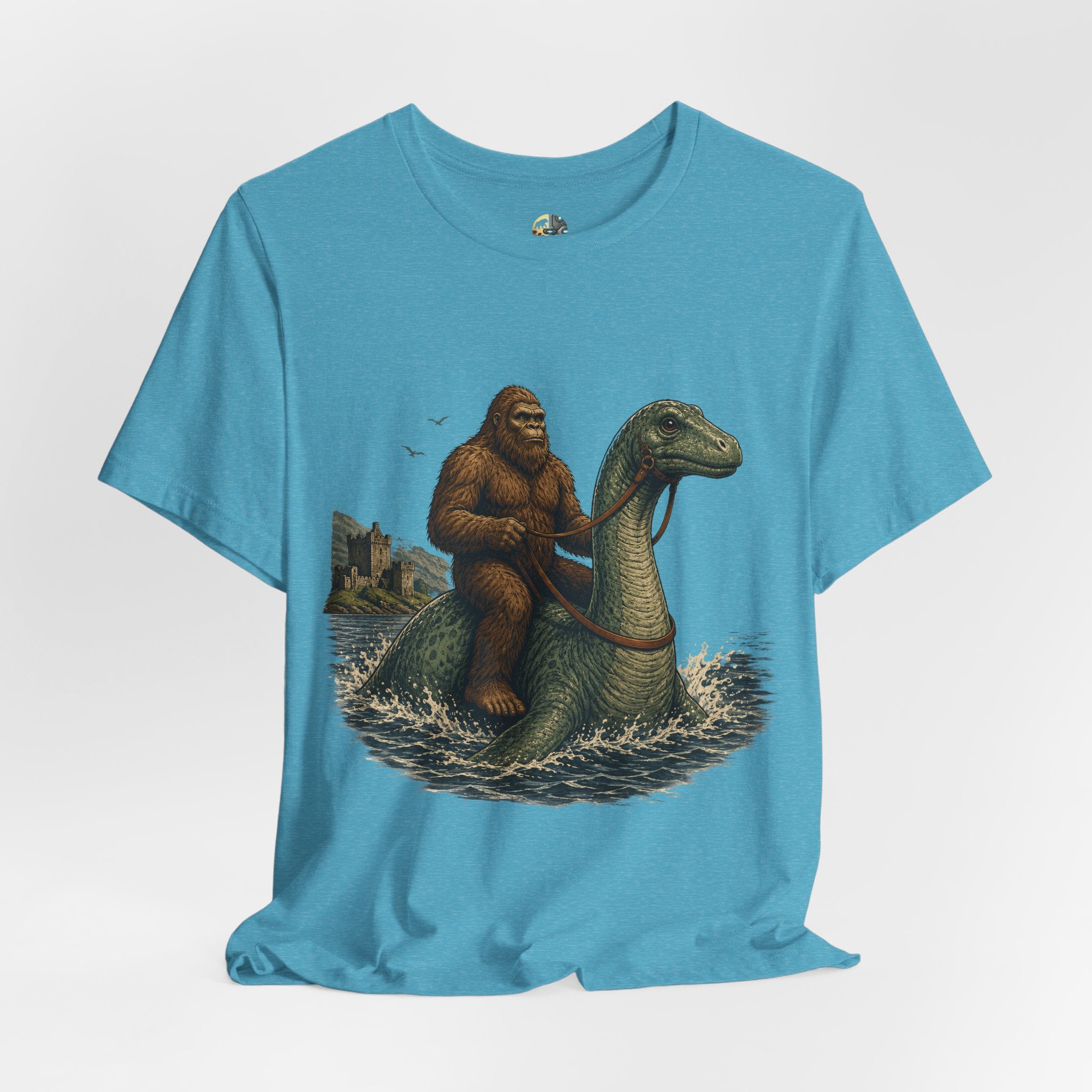 Heather aqua t-shirt featuring bigfoot riding on the Loch Ness monster