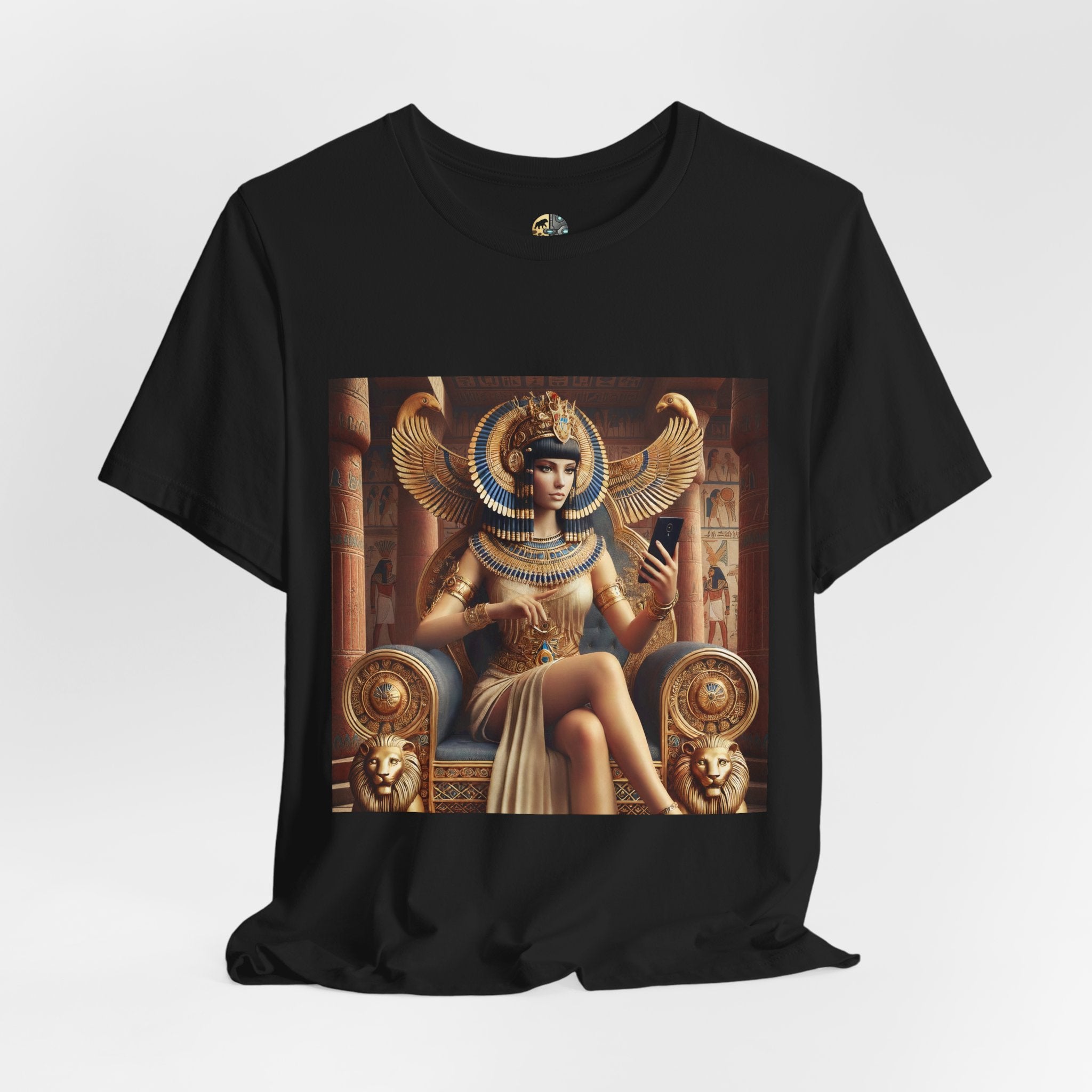Black T-shirt featuring a graphic of Cleopatra wearing an ornate headdress and gold jewelry, seated on a throne and holding a smartphone for a selfie, with temple architecture in the background