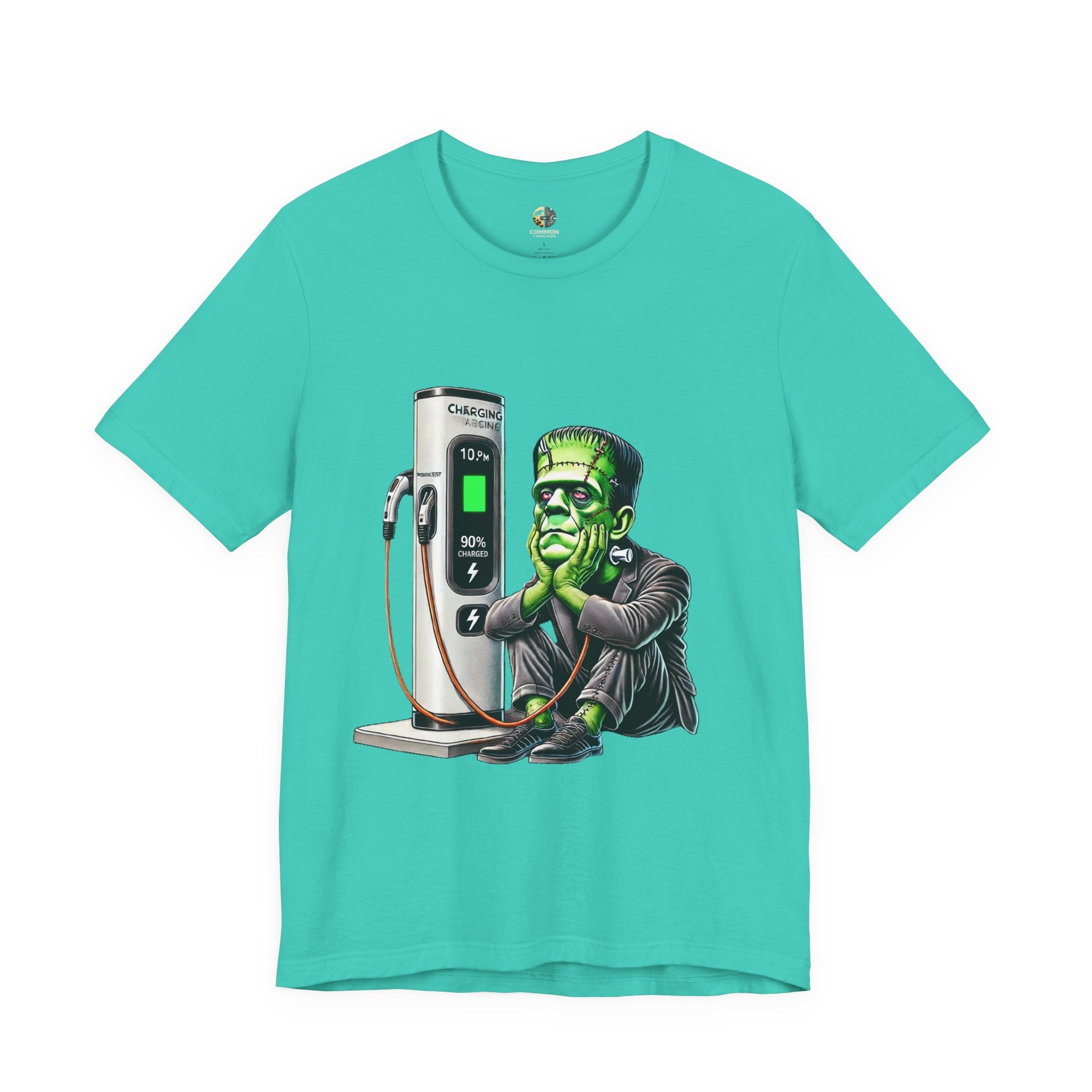 Teal T-shirt featuring a graphic of Frankenstein’s monster sitting at an electric charging station, plugged in and waiting for the charge to complete