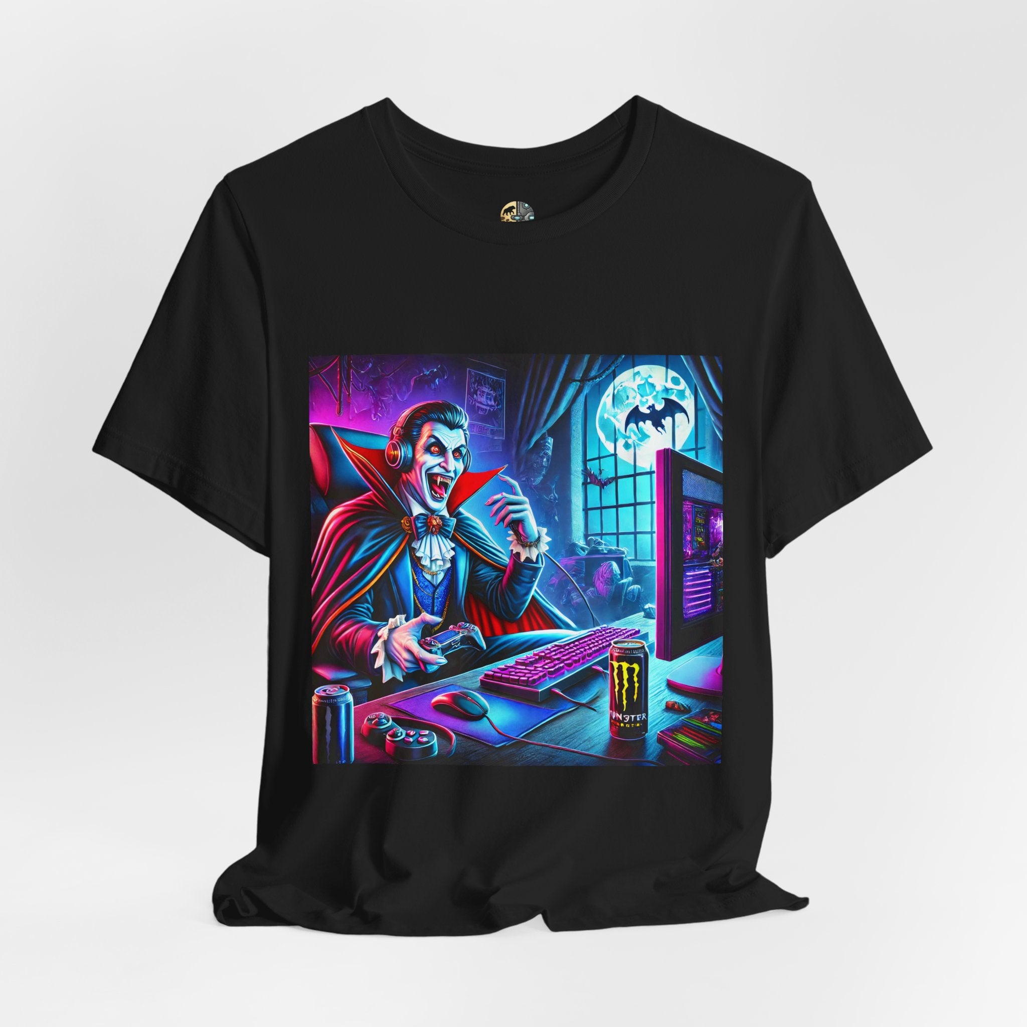 Black T-shirt graphic of a classic vampire wearing a gaming headset and holding a controller at a neon-lit gaming setup under a full moon