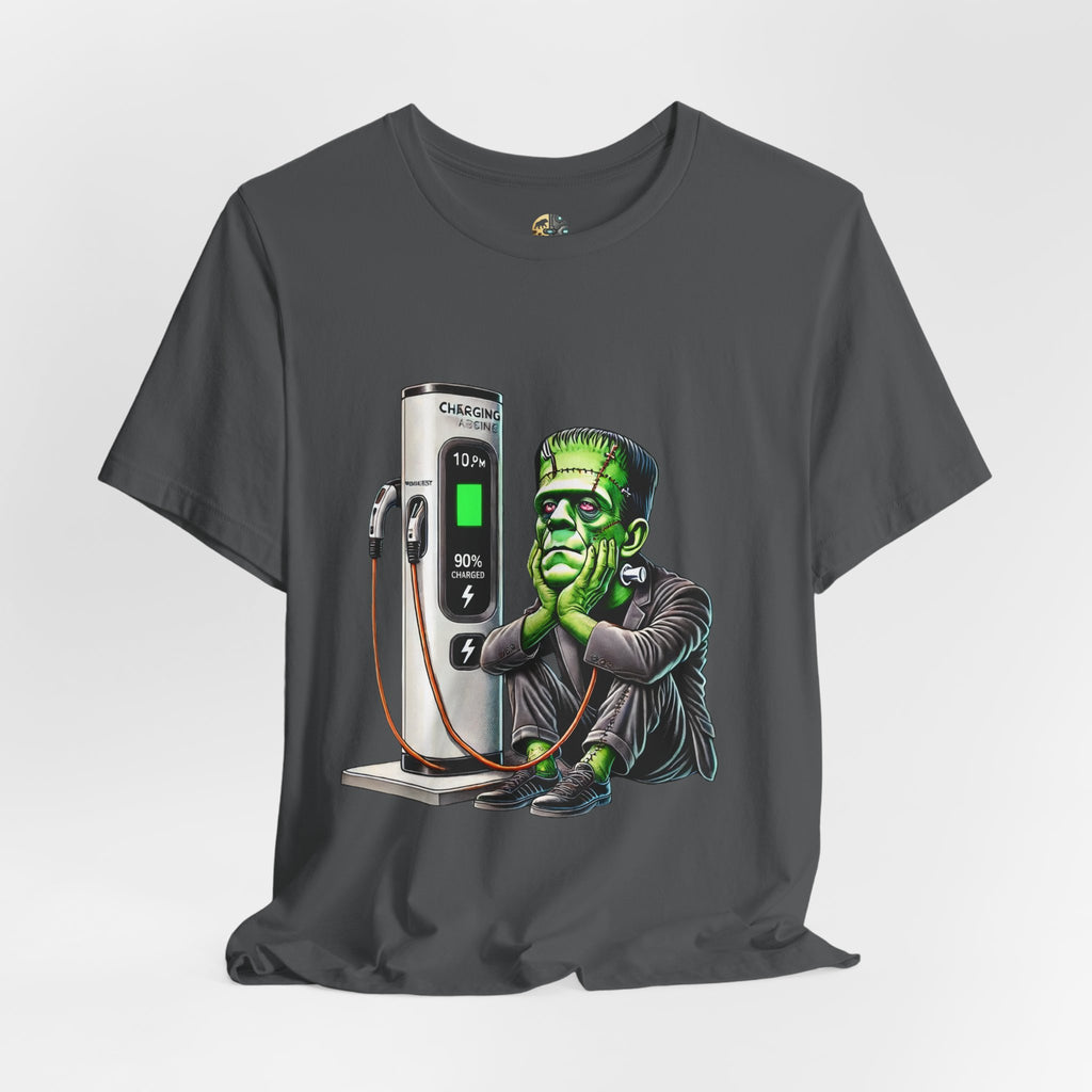 Asphalt grey T-shirt featuring a graphic of Frankenstein’s monster sitting at an electric charging station, plugged in and waiting for the charge to complete