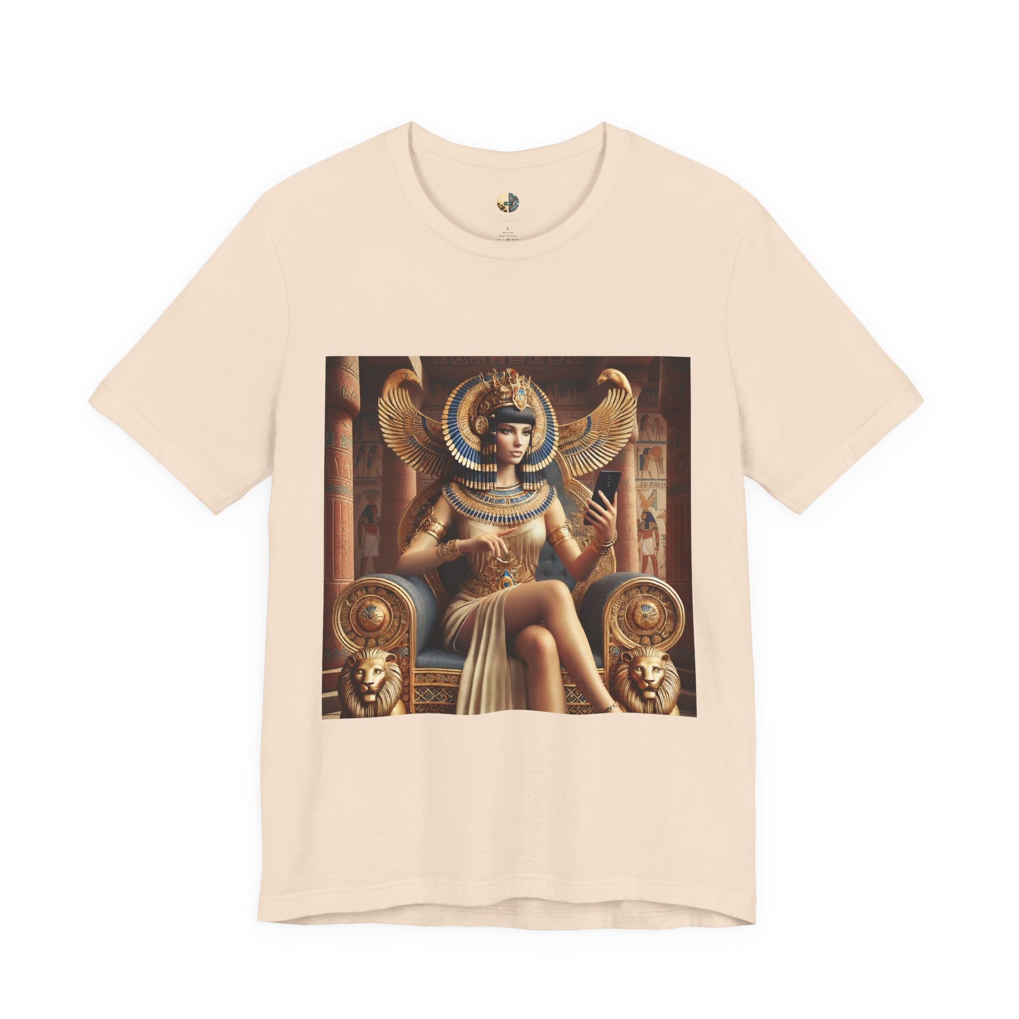 Soft creme T-shirt featuring a graphic of Cleopatra wearing an ornate headdress and gold jewelry, seated on a throne and holding a smartphone for a selfie, with temple architecture in the background