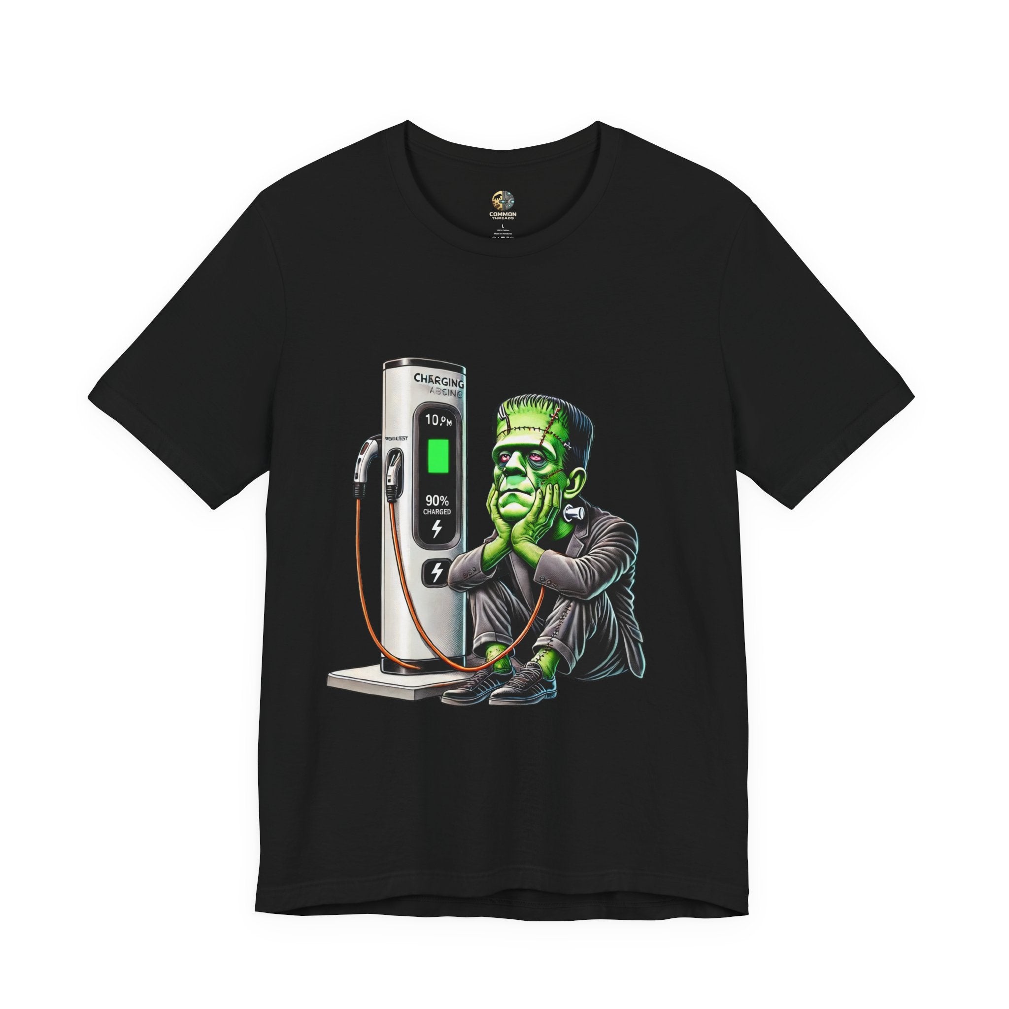 Black T-shirt featuring a graphic of Frankenstein’s monster sitting at an electric charging station, plugged in and waiting for the charge to complete