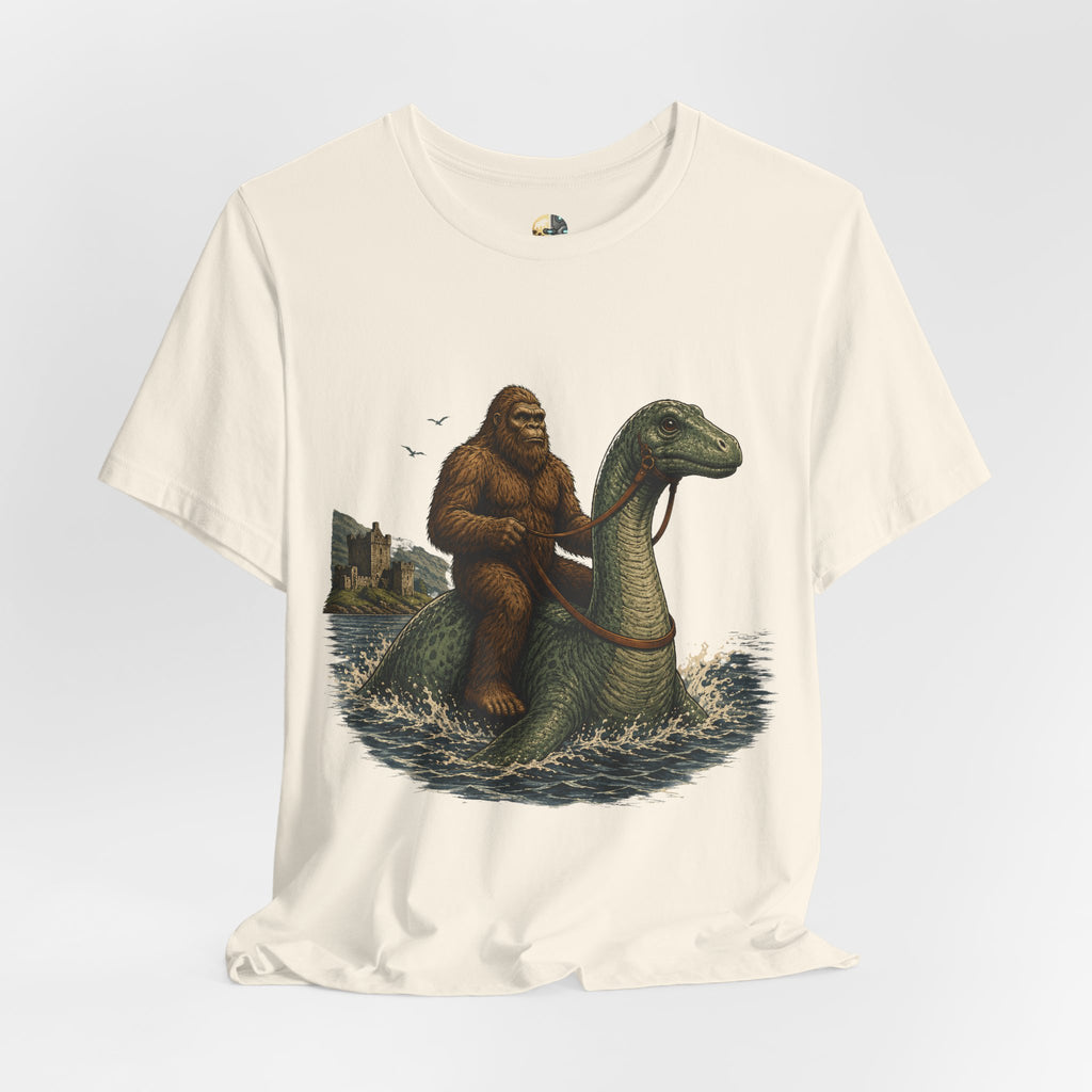 Natural color t-shirt featuring bigfoot riding on the Loch Ness monster