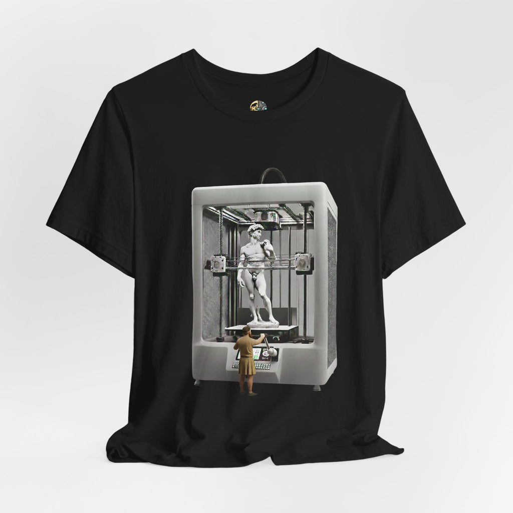 Black T-shirt featuring a graphic of Michelangelo’s David statue being created inside a large 3D printer, with Michelangelo standing at the controls