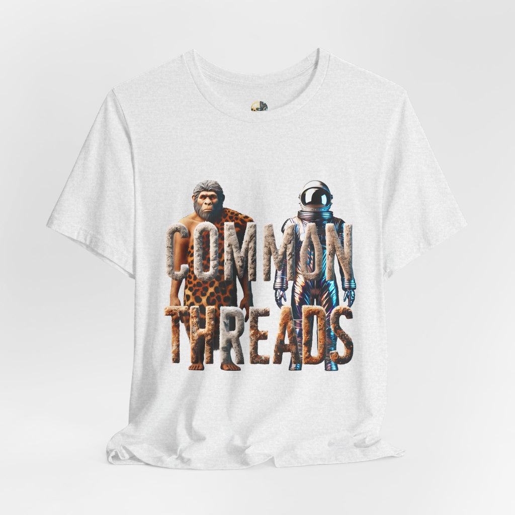 Ash color T-shirt featuring a graphic of a caveman in animal pelts standing beside a chrome-plated astronaut, with the text ‘Common Threads‘