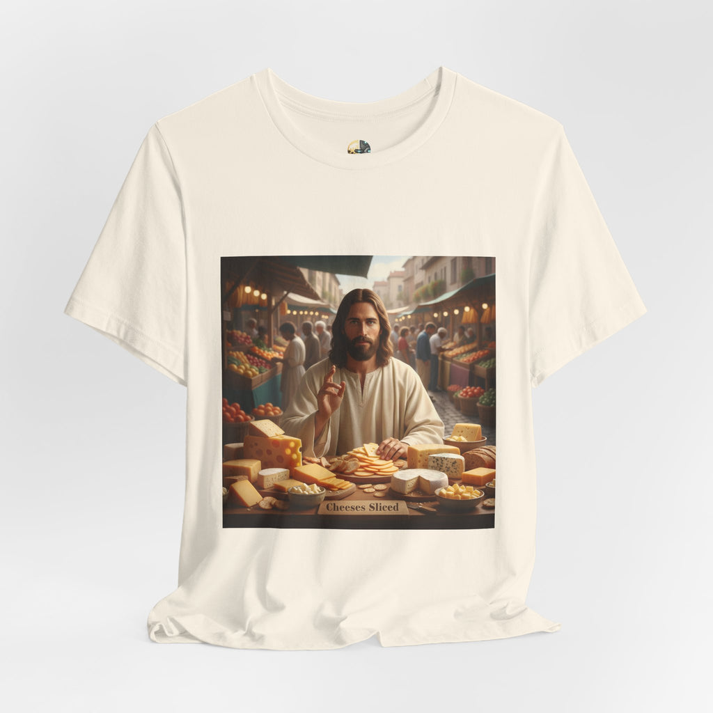 Natural color T-shirt featuring a graphic of Jesus in traditional robes at an ancient marketplace selling assorted cheeses, with a sign reading ‘Cheeses Sliced‘