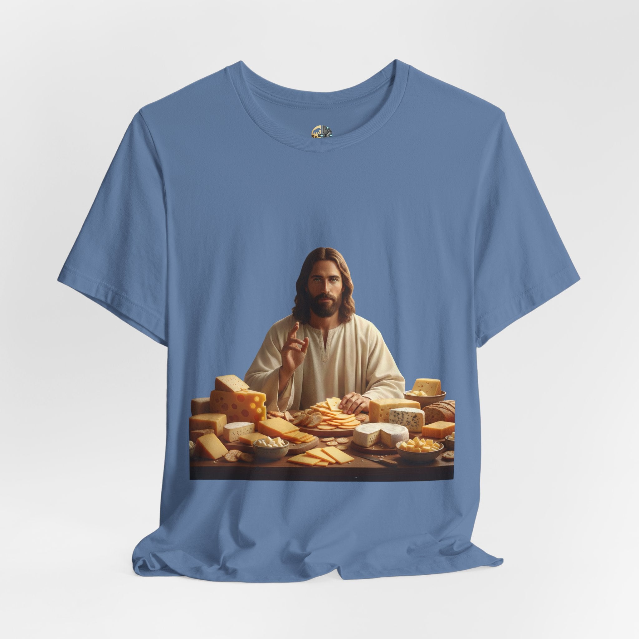 Lavender blue T-shirt featuring a graphic of Jesus in traditional robes seated before a table filled with various cheeses, referencing a ‘Cheeses Sliced’ wordplay