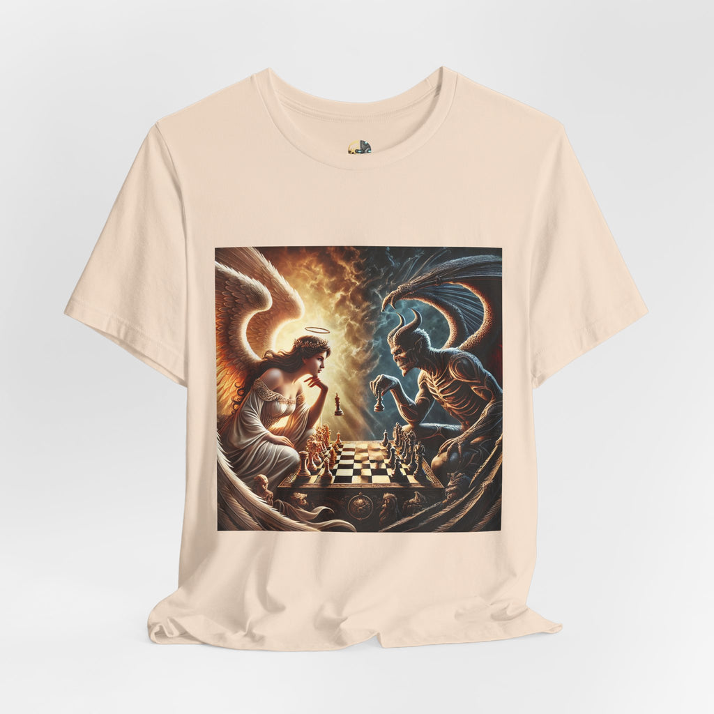 Soft creme T-shirt featuring a graphic of an angel and a demon playing chess, with a golden king piece levitating, a dark background behind the demon and warm light tones behind the angel