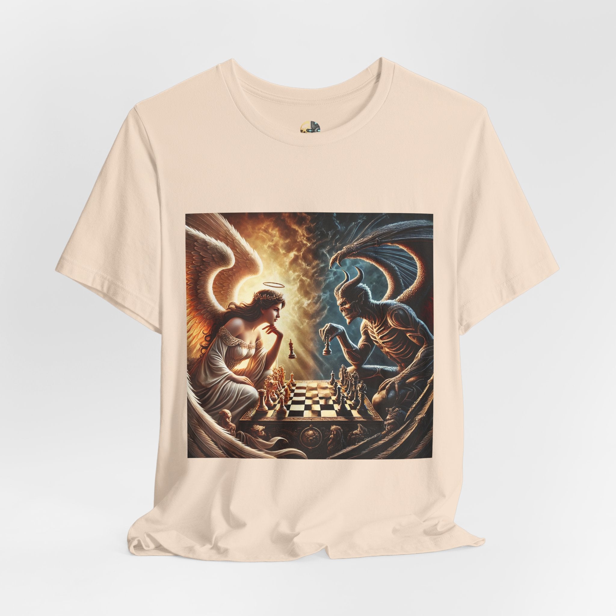 Soft creme T-shirt featuring a graphic of an angel and a demon playing chess, with a golden king piece levitating, a dark background behind the demon and warm light tones behind the angel