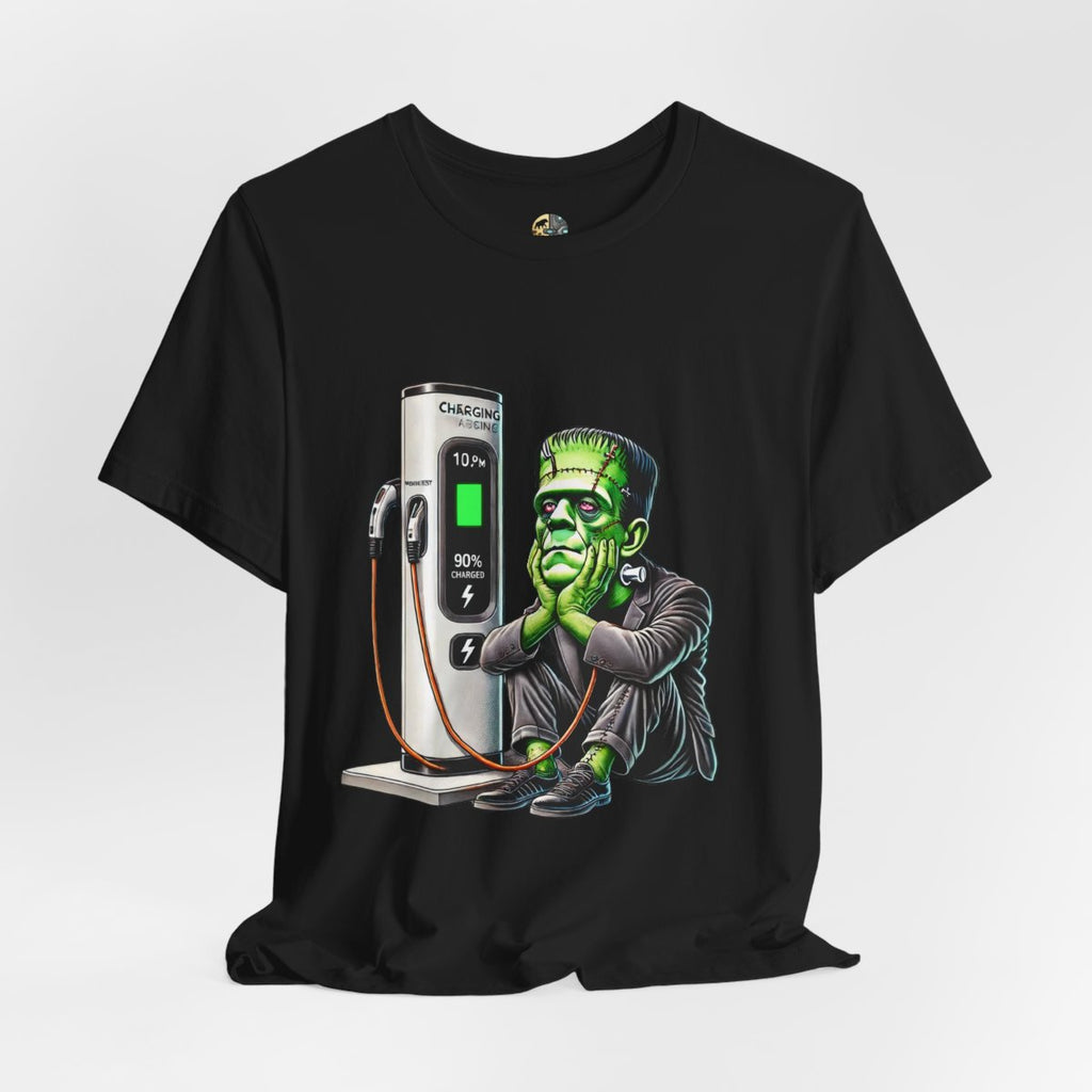 Black T-shirt featuring a graphic of Frankenstein’s monster sitting at an electric charging station, plugged in and waiting for the charge to complete